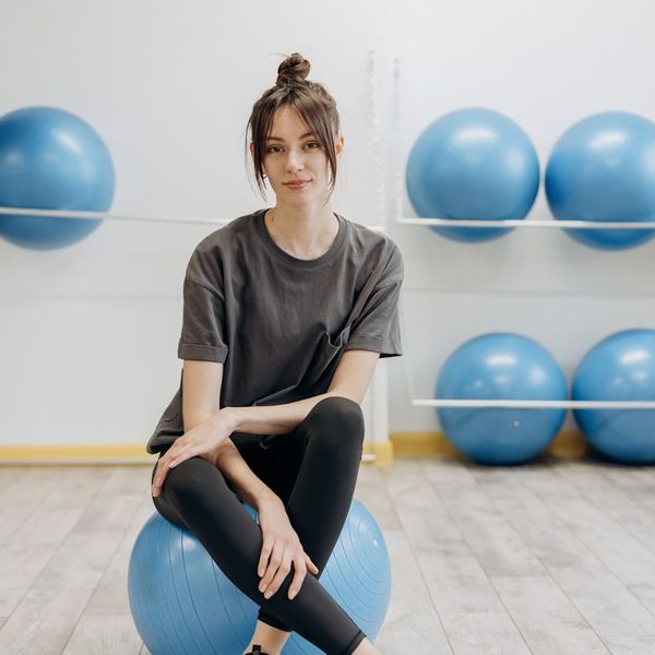 Woman in a calm yoga pose inside a smoky circle with azure accents.